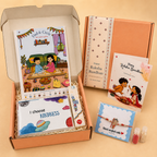 A curated gift box set displayed on a warm beige background, featuring an open peach-colored box filled with children's books, a card, and a bracelet, alongside a closed matching box and two small decorative packets.