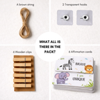 Packaging of wooden clips, brown string, transparent hooks, and affirmation cards on a white background.