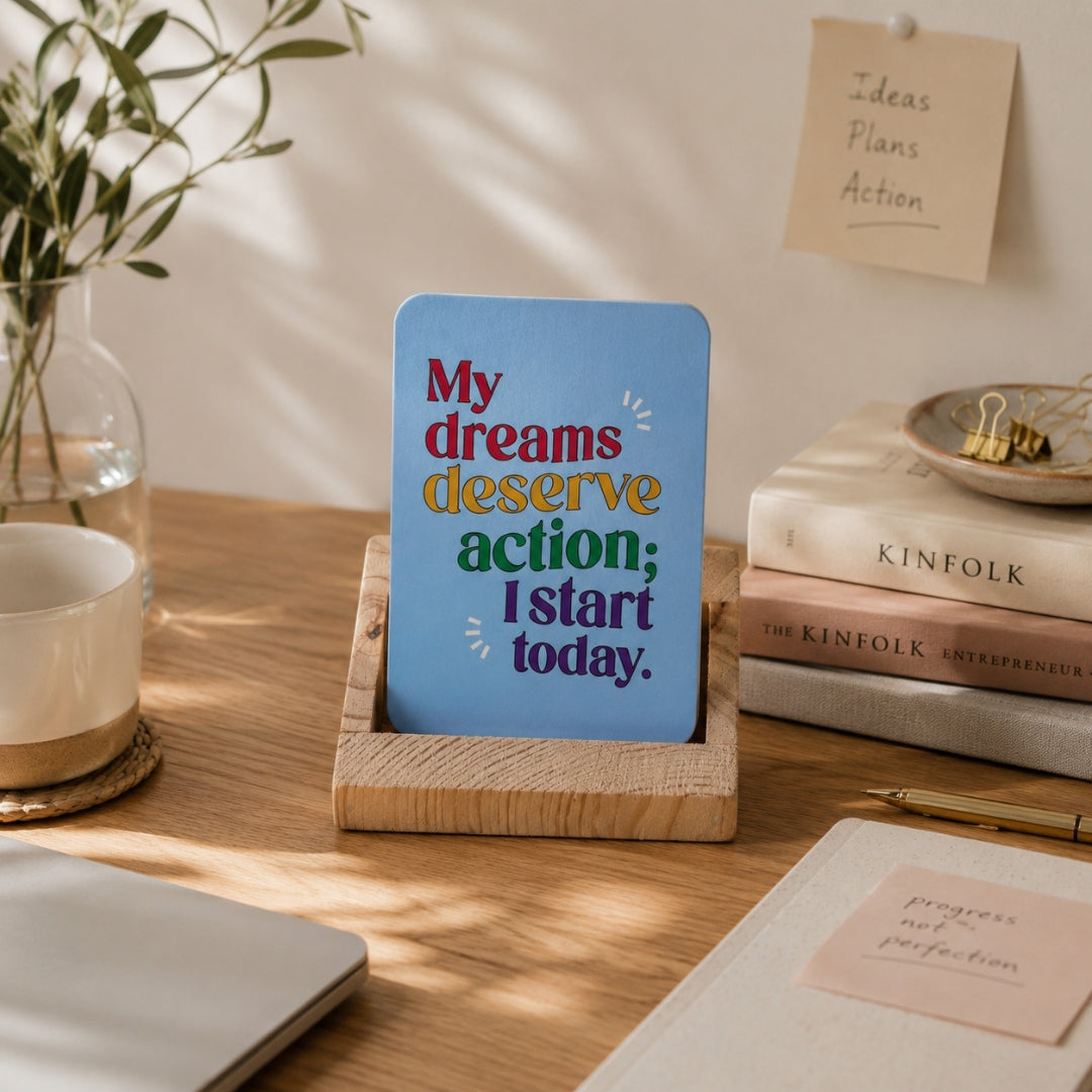 Motivational card with inspirational quote on a wooden stand, surrounded by books and stationery items.